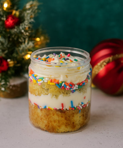 Layered cake in a jar with colorful sprinkles against a festive background